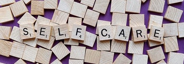SELF CARE spelled out in scrabble tiles